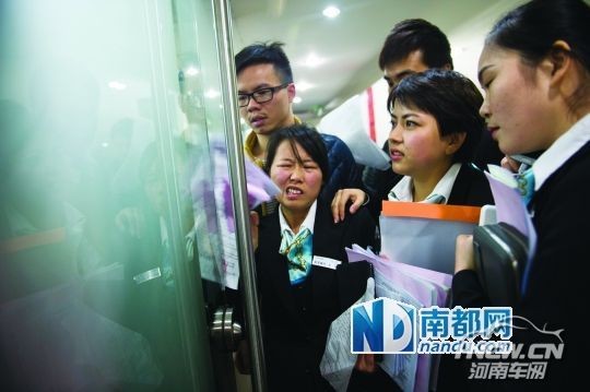 昨日19：37，在香蜜湖汽车城某4S店，限牌令已经实施一个半小时，但是业务员还在为顾客争取领到车钥匙，一名女子被挤得露出了难受的表情。南都记者 陈文才 摄